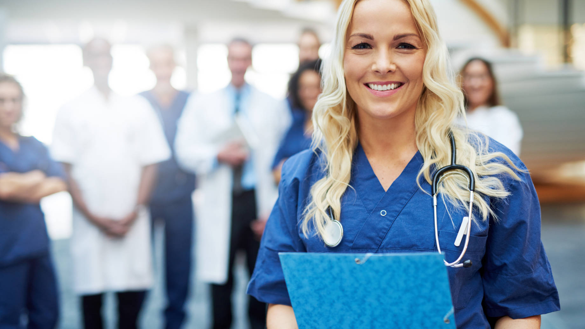 Cheerful blond medic with documents in hospital